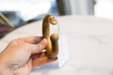 Antique African bronze cuff bracelet held in hand, showing its substantial form.