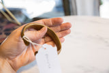 Antique bronze cuff bracelet held in hand to show its scale and smooth finish.