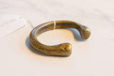 Hand-carved snake head with a simple eye on an antique bronze African cuff bracelet.