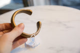 Antique bronze snake cuff held to display its handmade shape and aged finish.