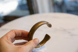 Antique bronze snake cuff held in hand, showing its scale and aged patina.