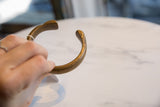 Angled view of the antique African bronze snake cuff's open design and patina.