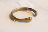 The simple, open form of an antique African bronze cuff with a time-softened patina.