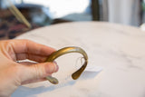 The C-shaped form and warm, aged patina of the antique bronze snake cuff.