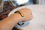Antique bronze snake cuff bracelet worn on a wrist, demonstrating its scale and smooth finish.
