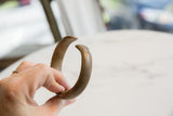 Antique African bronze cuff bracelet showing its smooth, open shape and dark patina.