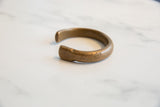 Side profile of the antique bronze snake cuff bracelet showing its open form.