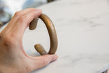 The solid, curved profile and aged bronze patina of the antique snake cuff.