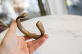 A profile view of the antique bronze cuff, highlighting its solid form and aged patina.