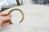 Profile of an antique African cuff showing its solid form and rich golden patina.