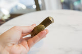 Showing the smooth, rounded end and warm golden patina of the antique bronze cuff.
