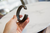 Antique African copper alloy bracelet held to show its substantial cuff shape and scale.