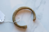 Detailed craftsmanship of an antique African bronze cuff showing its etched patterns.