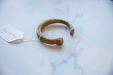 Side profile of the antique bronze snake cuff bracelet, showing its hand-formed shape.