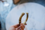 Antique African bronze cuff held in hand, showing its warm golden patina.