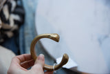 Smooth, rounded snake-head terminal of the antique African bronze cuff bracelet.