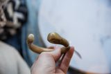 Close view of the antique African bronze cuff's stylized snake head ends.