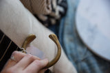 Stamped circular markings and aged patina on the terminal of the antique bronze snake cuff.