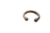 Antique African copper alloy snake cuff bracelet with stylized ends and a dark patina.