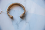 Hand-stamped markings and patina on the terminals of the antique copper cuff.