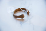 Close-up of the antique snake cuff's head, showing handcrafted markings and smooth patina.