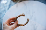 Hand-formed snake head terminal with stamped marks on an antique African copper cuff.
