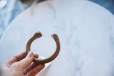 Antique copper snake cuff bracelet held in hand to show its scale and curved form.