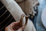 Small maker's mark stamped on the smooth, rounded tip of the antique copper alloy cuff.