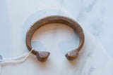 Antique copper alloy bracelet showing its rich patina and hand-etched line work.