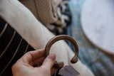 Antique African copper cuff bracelet held in hand, with a warm, aged patina.