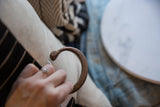 Antique copper snake cuff bracelet held in hand showing its form and rich aged patina.