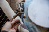 Antique African snake cuff bracelet held in hand, demonstrating its size and form.
