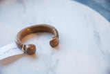 Antique African copper bracelet showing its open cuff and snake head ends.