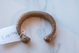Rich copper patina on an antique African snake cuff with etched details.