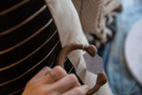 The warm patina of a copper alloy snake bracelet held in hand.
