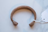 The hand-etched surface and rich patina of an antique African copper cuff.