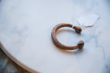 Antique African copper cuff bracelet showing its full C-shape and time-softened patina.