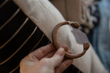 Antique copper snake cuff held in hand, displaying its handcrafted shape and patina.