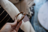 Antique African copper bracelet held to show its handcrafted form and patina.