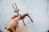 Vintage bronze gazelle held in hand to show its slender form and scale.