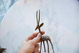 Side profile of the vintage African bronze gazelle held to show scale and texture.