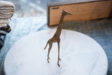 Vintage African bronze giraffe figurine with unique handmade texture and patina.