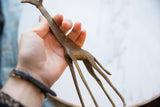 Vintage African bronze giraffe's textured body and slender legs, held in hand.