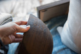 Dark antique African wooden bowl with hand-carved geometric patterns and aged wood texture.