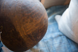 Curved surface of an antique African wooden bowl, highlighting rich brown patina and subtle etched patterns.