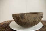 Rustic dark wood texture of the vintage African bowl, showing cracks and repairs.