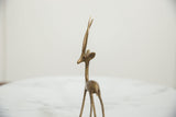 Close-up of vintage African bronze gazelle, showing head, stylized horns, and rich patina.