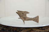 The rustic, hand-formed texture and aged patina on the vintage African bronze fish.