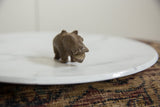 The carved face and open mouth of a vintage African bronze hippo sculpture.