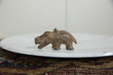Profile view of a vintage bronze hippo highlighting its rustic handmade texture.